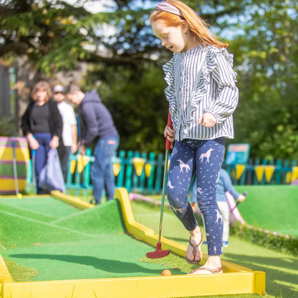 little girl playing crazy golf